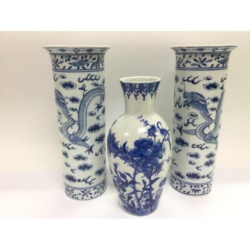 1012 - Three blue and white Oriental vases comprising a pair decorated with a dragon chasing a pearl approx... 