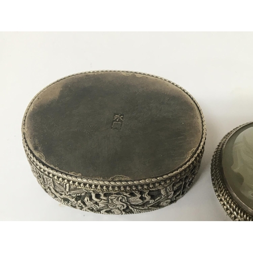 1030 - A Chinese white metal and jade mounted box of oval shape with a detachable lid the side with blind f... 