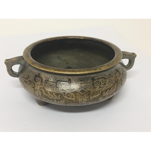 1034 - A Chinese bronze Censor with a fine silvered pattern raised side handles and impressed caricature ma... 