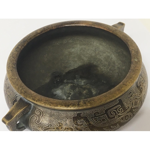 1034 - A Chinese bronze Censor with a fine silvered pattern raised side handles and impressed caricature ma... 