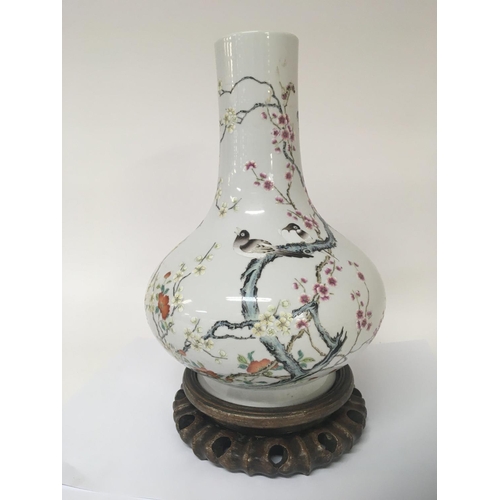 1043 - A Chinese porcelain bottle vase enamel decorated with flowers foliage and birds caricature marks to ... 