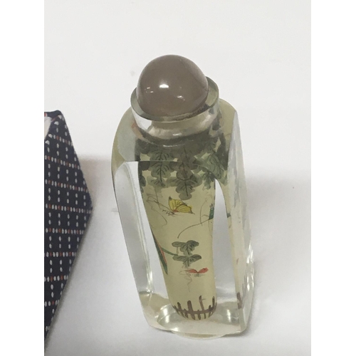 1052 - A 20th Century hand painted glass scent bottle painted with flowers and insects.