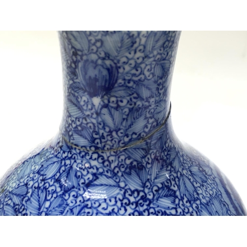 1058 - Chinese blue and white vases with floral decoration, one with restoration. 11 and 22cm tall. Postage... 