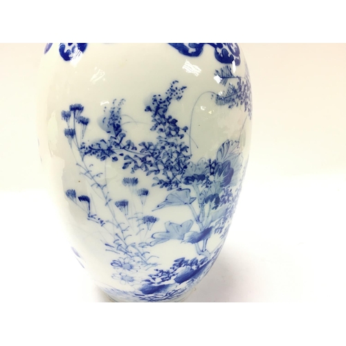 1058 - Chinese blue and white vases with floral decoration, one with restoration. 11 and 22cm tall. Postage... 