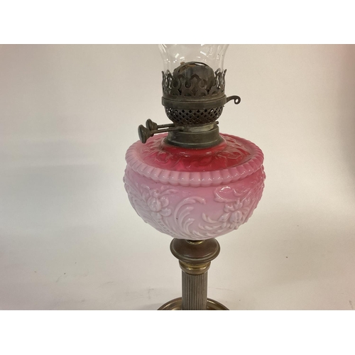 1114 - A Victorian pink glass oil lamp. 66cm tall. Postage D