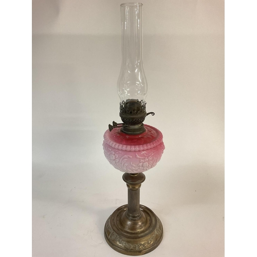 1114 - A Victorian pink glass oil lamp. 66cm tall. Postage D