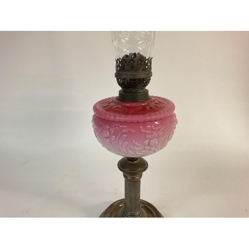 1114 - A Victorian pink glass oil lamp. 66cm tall. Postage D