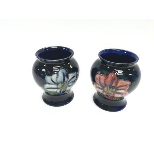 1202 - Two small Moorcroft vases both 8cm tall. The left one has a crack other is in good condition.-