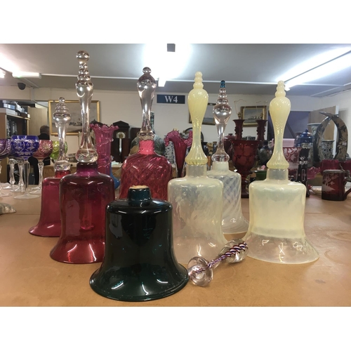 1327 - A collection of Victorian glass bells, including cranberry coloured and barley twist handles.