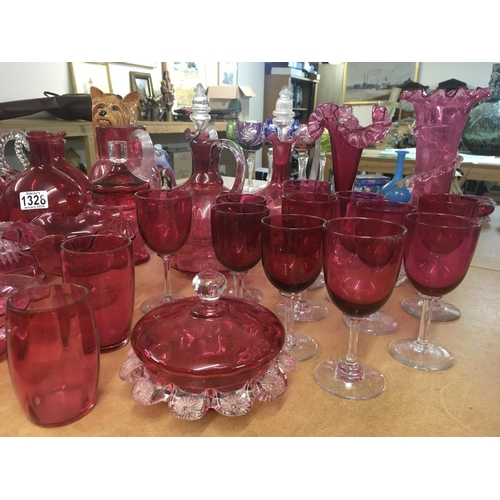 1328 - A large collection of Victorian cranberry glassware including decanters with stoppers, vases, jugs, ... 