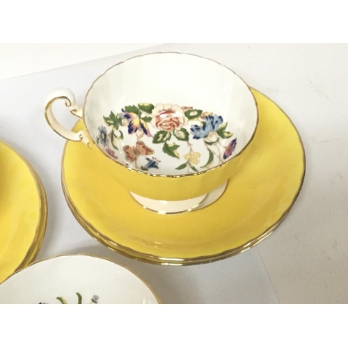 1354 - A decorative Anynsley porcelain tea set yellow glazed decorated with flowers and foliage.one other c... 