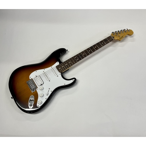 2396 - A Squier Stratocaster guitar in Fender Tweed Case in as new condition. Shipping category D.