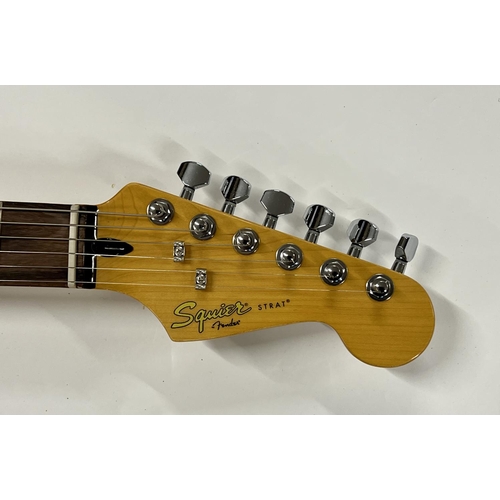 2396 - A Squier Stratocaster guitar in Fender Tweed Case in as new condition. Shipping category D.