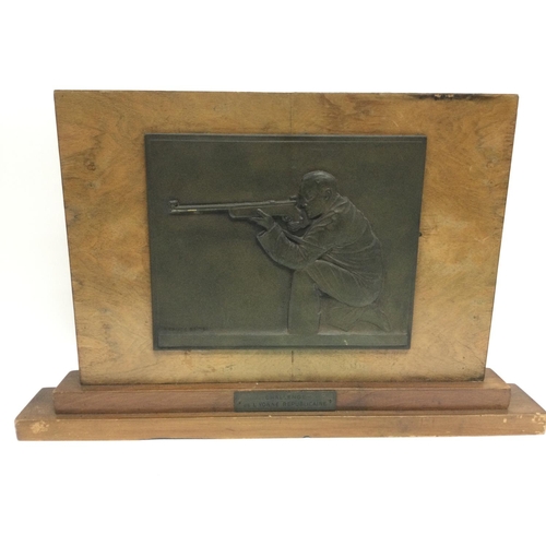 966 - A bronzed olympic shooting plaque mounted on a wooden base by Fraisse Demey, approx width 52.5cm. Sh... 