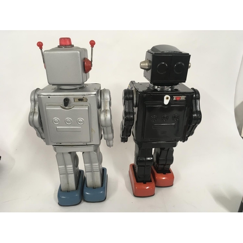 103 - A pair of tinplate model battery operated robots with numerous features. One marked made in Japan th... 