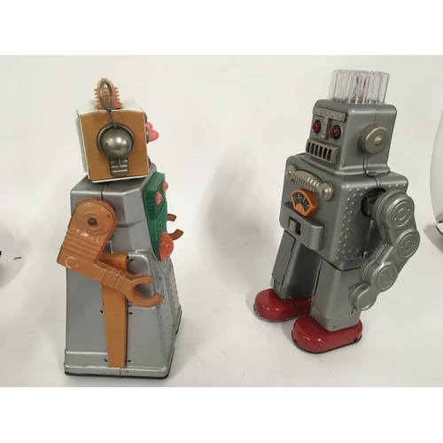 104 - A pair of tinplate battery operated robots one marked HaHa toys and the other HK made in Japan.