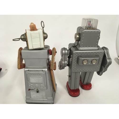 104 - A pair of tinplate battery operated robots one marked HaHa toys and the other HK made in Japan.