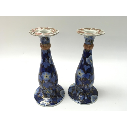 1008 - A pair of Japanese candle stick holders. One with repair to the top. 19cm tall.Postage D