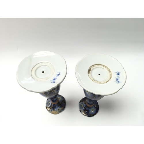 1008 - A pair of Japanese candle stick holders. One with repair to the top. 19cm tall.Postage D