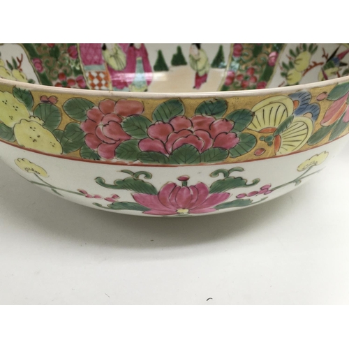 1018 - A Chinese canton style bowl decorated with figures flowers and foliage.