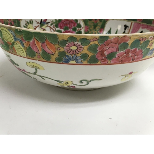 1018 - A Chinese canton style bowl decorated with figures flowers and foliage.