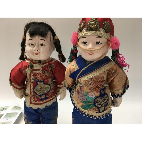 1020 - A pair of Chinese dolls in traditional costume dress. 25 cm