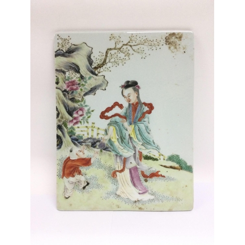 1026 - An Oriental ceramic tile with handpainted decoration of a mother and child in a garden setting, appr... 