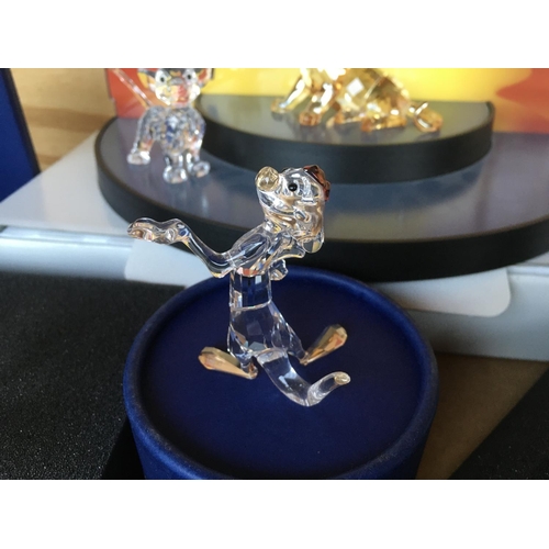 1113 - A collection of Swarovski Disney Characters from The Lion King, together with a golden lion. Togethe... 