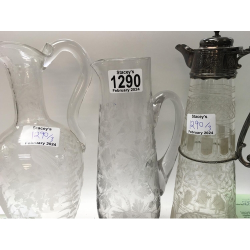 1290 - A glass claret jug with silver plated mounts and etched sides and two other etched jugs .