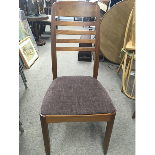 1489 - A modern teak dining table and four chairs. Table diameter approx 100cm.