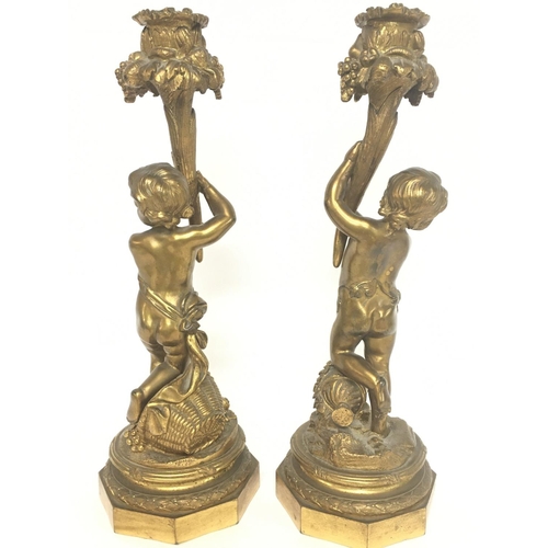 964 - A pair of 19th Century French gilted bronze putti candlesticks with floral decoration, 28cm tall. Po... 