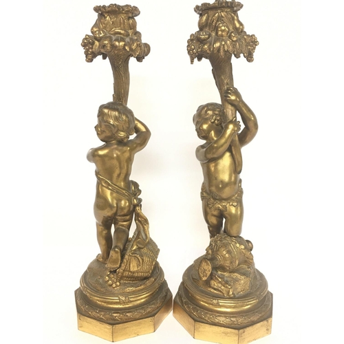 964 - A pair of 19th Century French gilted bronze putti candlesticks with floral decoration, 28cm tall. Po... 