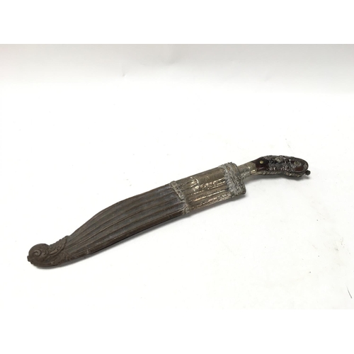 992 - A unusual white metal and carved wood dagger, possibly 18th century with a shape and decorative grip... 