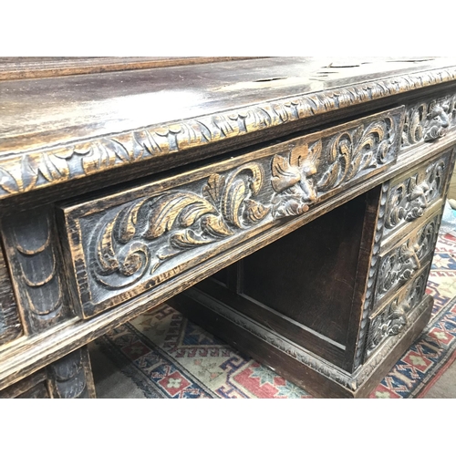1353 - A Late Victorian oak carved desk with leather top, dimensions 75x152x126cm