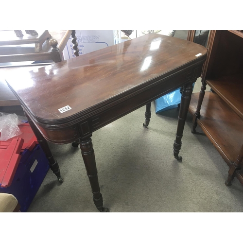 1252 - A late George III mahogany card table with a hinged top on turned legs.