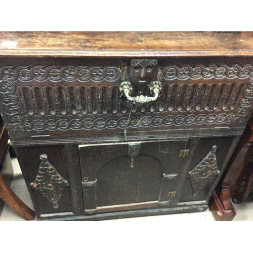 1335 - An 18th Century carved oak two section cabinet cupboard the top section with an open arch above a fa... 