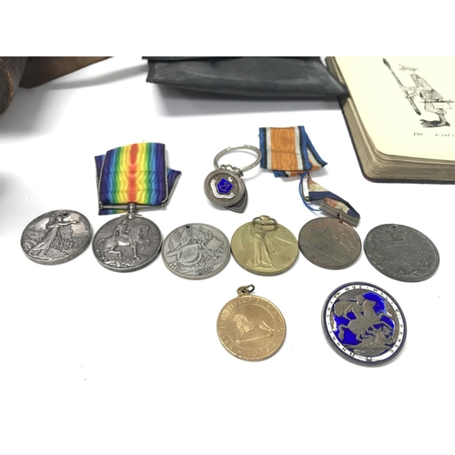 1555 - A collection of assorted medals and badges including a 9ct gold example. Lot including book with som... 