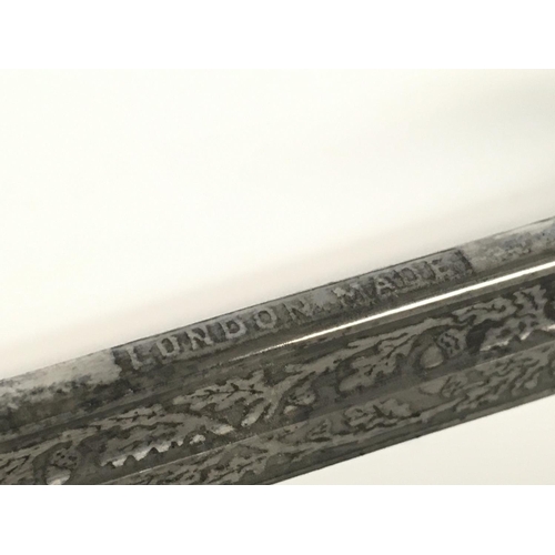 1579 - A 19th Century British Naval officers sword with leather scabbard. 32 Inch ornately decorated blade ... 