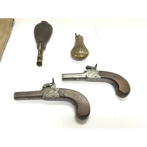 1589 - A pair of English percussion cap pistols with walnut grips. Marked Fenton London. Also two powder fl... 