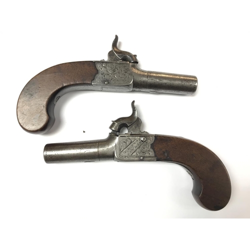 1589 - A pair of English percussion cap pistols with walnut grips. Marked Fenton London. Also two powder fl... 