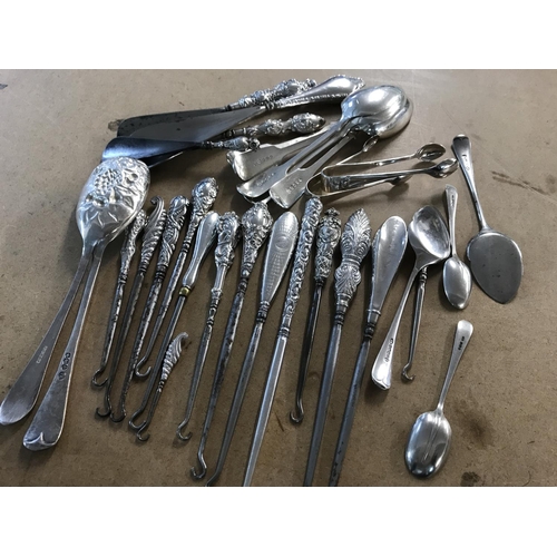 749 - A collection of silver handled button hooks together with shoe horns, serving spoons, tea spoons var... 