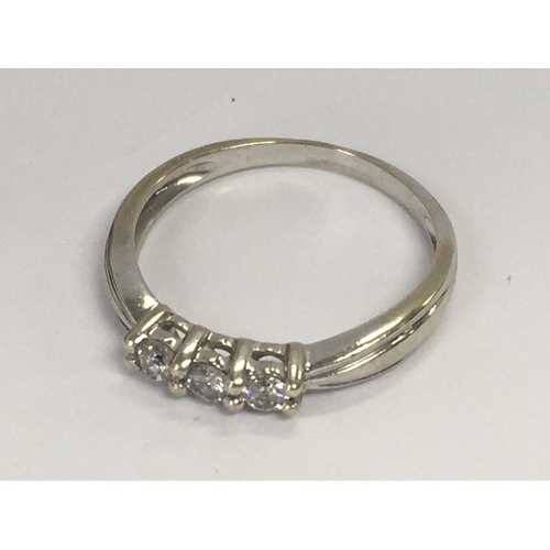 793 - A 9ct white gold ring inset with a row of three diamonds