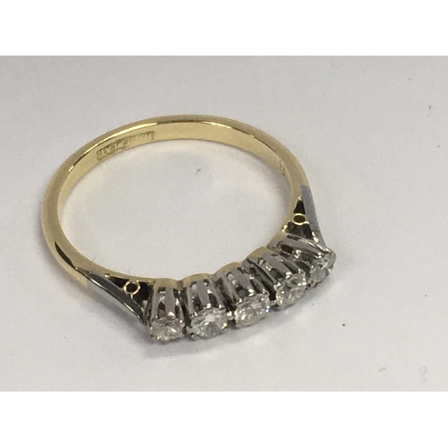 794 - An 18ct gold and platinum ring inset with a row of five diamonds