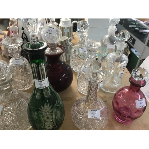 965 - A large collection of mixed decanters including cut glass and coloured glass decanters and more. App... 