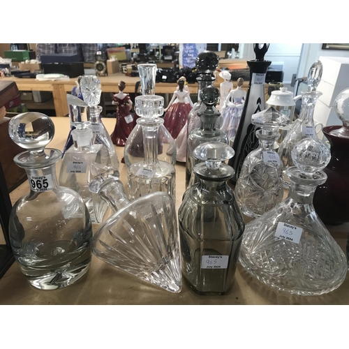 965 - A large collection of mixed decanters including cut glass and coloured glass decanters and more. App... 