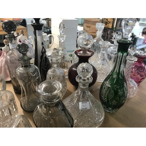 965 - A large collection of mixed decanters including cut glass and coloured glass decanters and more. App... 