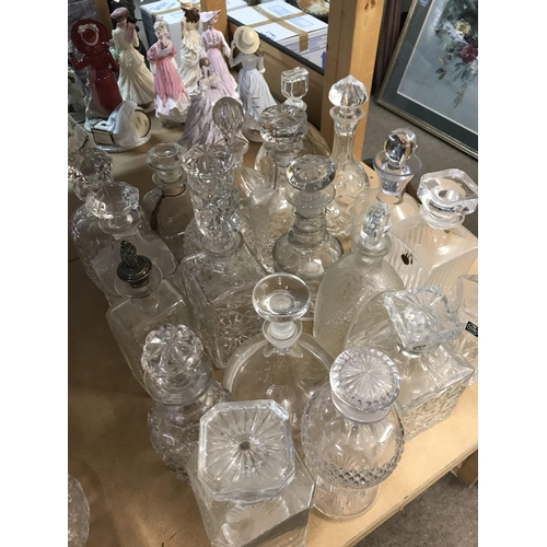 973 - A large collection of decanters including cut glass examples. Approx 20 decanters.