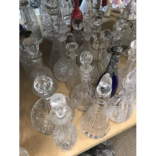 974 - A large collection of decanters including some silver plated and cut glass examples. Approx 20 decan... 