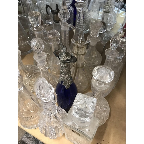 974 - A large collection of decanters including some silver plated and cut glass examples. Approx 20 decan... 