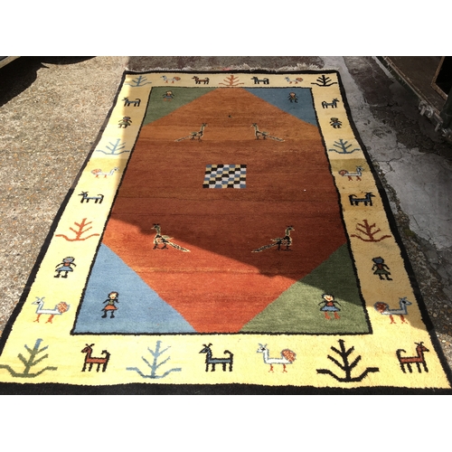 1228 - A large Gabbeh style rug decorated with peacocks and other animals. Dimensions 245x165 approximately